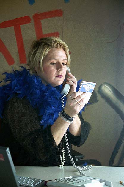 Linda achter telefoon in "Working"